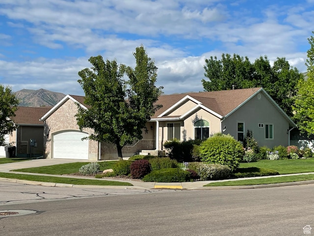 2285 S 450 W, Perry, UT 84302 - ranch-style house with concrete driveway, an attached garage, stucco siding, and a mountain view
