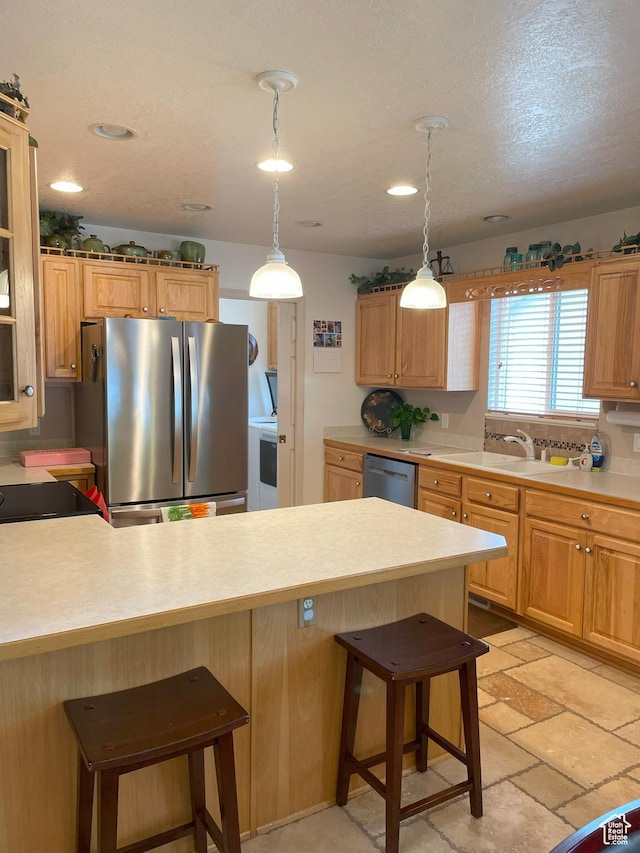 2285 S 450 W, Perry, UT 84302 - kitchen featuring stainless steel appliances, a kitchen bar, light countertops, pendant lighting, and a peninsula