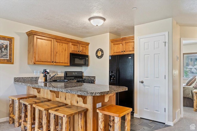 3521 N Fox Run Unit 812, Eden, UT 84310 - kitchen with black appliances, a sink, a breakfast bar area, a peninsula, and baseboards