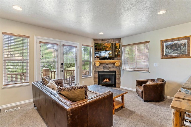 3521 N Fox Run Unit 812, Eden, UT 84310 - living area featuring light carpet, baseboards, a stone fireplace, a textured ceiling, and healthy amount of natural light
