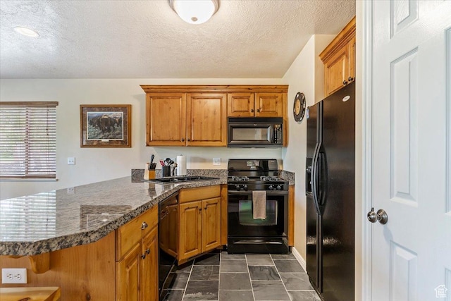 3521 N Fox Run Unit 812, Eden, UT 84310 - kitchen featuring black appliances, a peninsula, brown cabinetry, dark countertops, and a sink