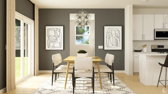 dining area featuring light wood-style floors, a chandelier, and baseboards