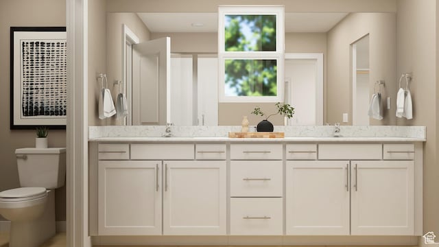 bathroom featuring toilet and double vanity