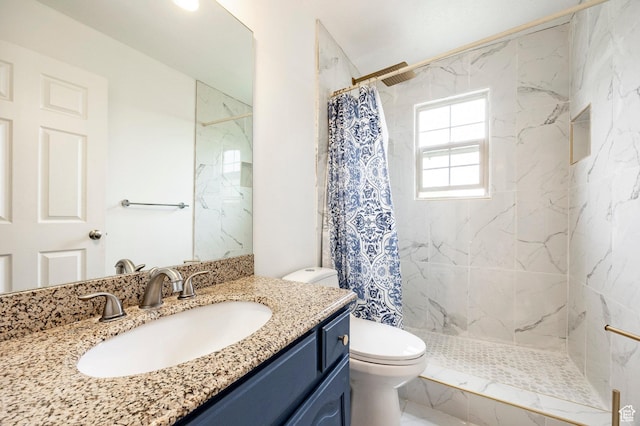 full bath featuring toilet, a tile shower, and vanity