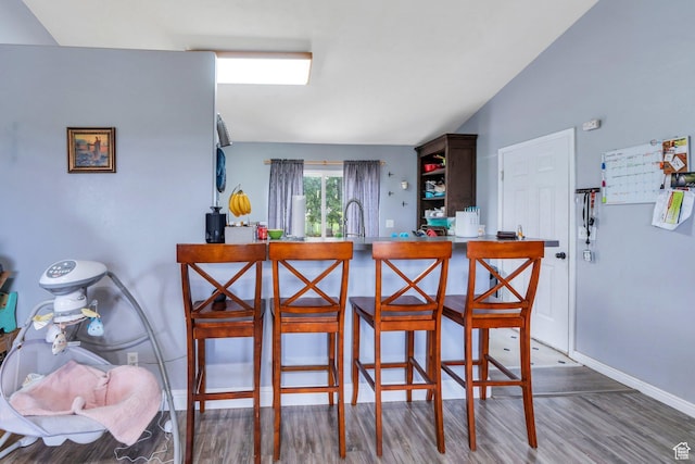606 N 560 W, Santaquin, UT 84655 - kitchen with wood finished floors, baseboards, a kitchen breakfast bar, and a peninsula