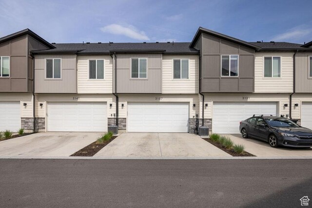 3137 S 225 W Unit 404, Nibley, UT 84321 - townhome / multi-family property featuring a garage, stone siding, and driveway