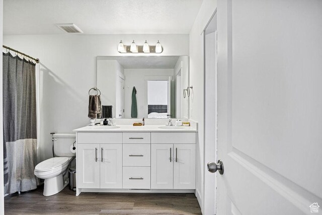 3137 S 225 W Unit 404, Nibley, UT 84321 - full bathroom featuring wood finished floors, double vanity, toilet, and a shower with shower curtain
