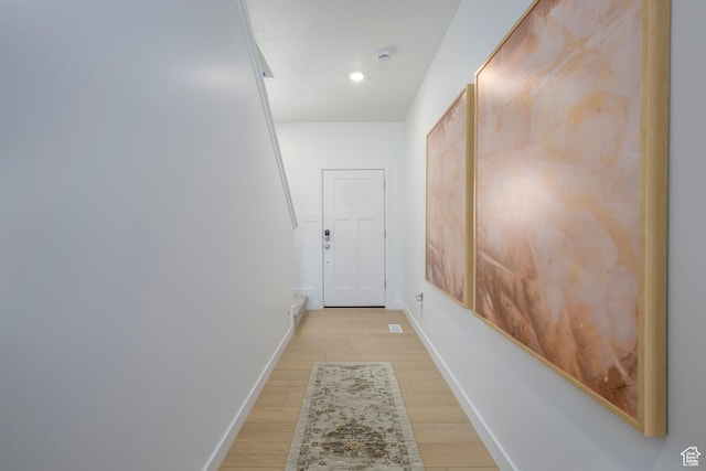 hall featuring baseboards and light wood-style flooring