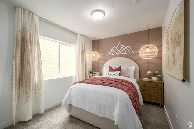 bedroom with carpet flooring, baseboards, and a textured ceiling