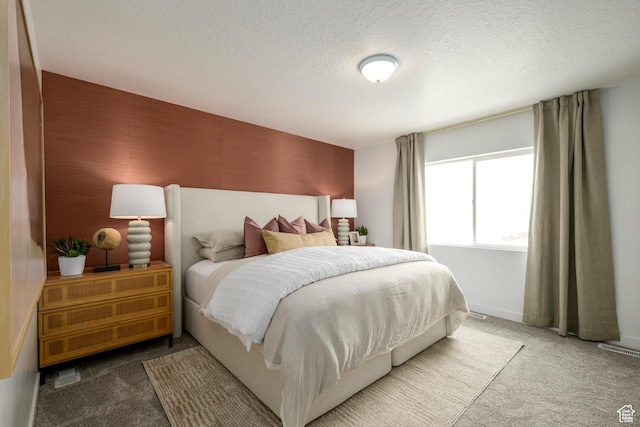 carpeted bedroom featuring a textured ceiling and baseboards