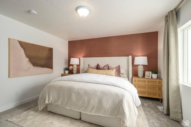 bedroom with carpet floors, baseboards, and an accent wall