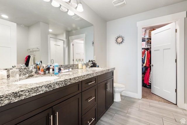 4483 S Parkbury Way, Salt Lake City, UT 84129 - bathroom with a stall shower, double vanity, a spacious closet, toilet, and baseboards
