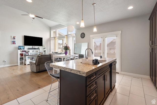 4483 S Parkbury Way, Salt Lake City, UT 84129 - kitchen with a sink, a breakfast bar area, open floor plan, a textured ceiling, and dishwasher