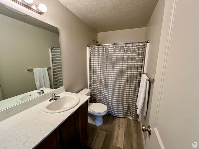 2594 E 600 N, Spanish Fork, UT 84660 - bathroom featuring wood finished floors, a textured ceiling, toilet, vanity, and curtained shower