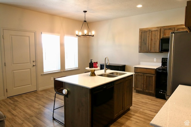 2594 E 600 N, Spanish Fork, UT 84660 - kitchen featuring black appliances, a sink, light countertops, light wood finished floors, and a chandelier