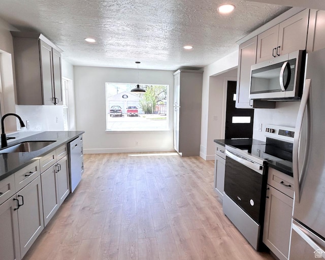 45 E 300 N, Roosevelt, UT 84066 - kitchen with stainless steel appliances, dark countertops, a textured ceiling, gray cabinets, and light wood-style flooring