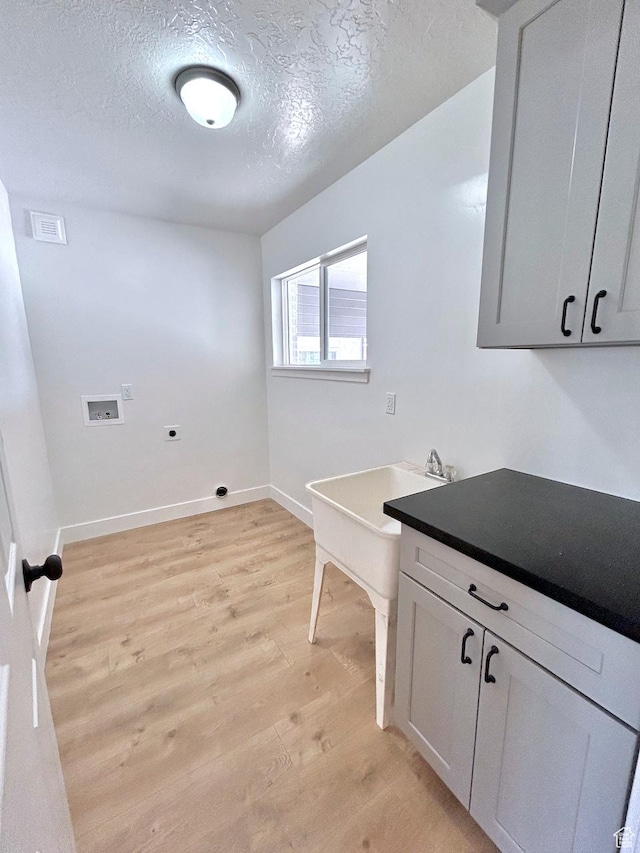45 E 300 N, Roosevelt, UT 84066 - washroom with hookup for an electric dryer, washer hookup, light wood-style floors, a textured ceiling, and cabinet space