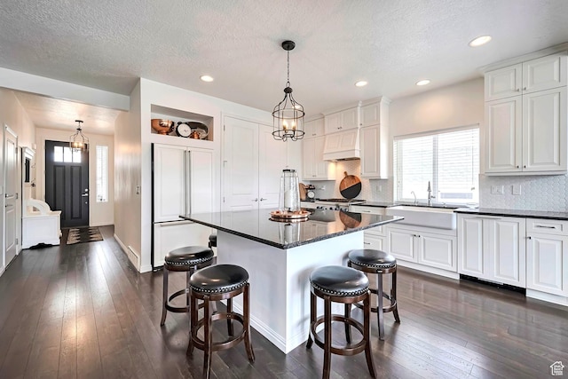 2178 S 60 E Unit 37, Heber City, UT 84032 - kitchen with a sink, paneled fridge, a kitchen breakfast bar, dark wood finished floors, and a textured ceiling