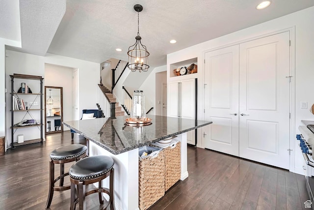 2178 S 60 E Unit 37, Heber City, UT 84032 - kitchen with dark wood-style flooring, a kitchen breakfast bar, a textured ceiling, dark stone counters, and recessed lighting