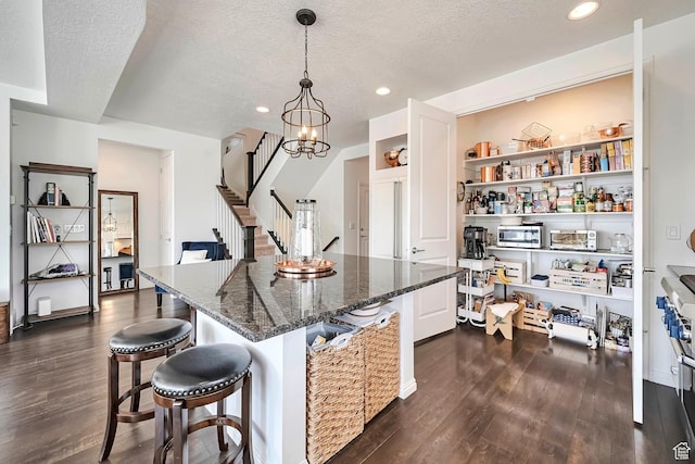 2178 S 60 E Unit 37, Heber City, UT 84032 - kitchen with dark wood-style floors, a textured ceiling, a kitchen breakfast bar, recessed lighting, and dark stone countertops
