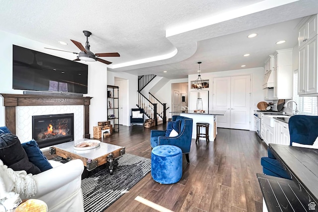2178 S 60 E Unit 37, Heber City, UT 84032 - living room featuring dark wood-type flooring, a tile fireplace, ceiling fan, stairs, and a textured ceiling