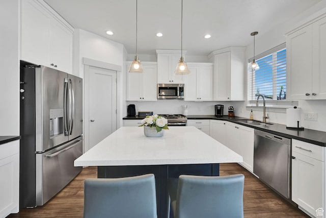 3507 S 4875 W, West Haven, UT 84401 - kitchen with appliances with stainless steel finishes, a sink, a kitchen island, white cabinets, and a kitchen breakfast bar