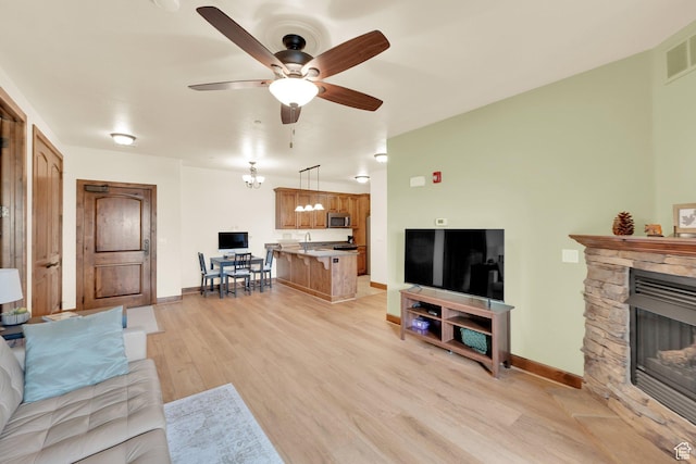 2011 S 2100 E Unit 308, Salt Lake City, UT 84108 - living area featuring light wood-type flooring, ceiling fan, a stone fireplace, and baseboards