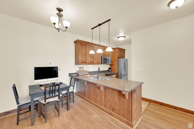 2011 S 2100 E Unit 308, Salt Lake City, UT 84108 - kitchen with appliances with stainless steel finishes, light wood-style floors, light stone counters, a peninsula, and brown cabinetry