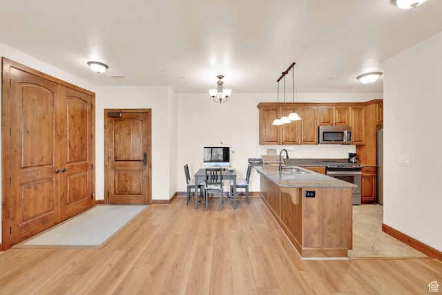 2011 S 2100 E Unit 308, Salt Lake City, UT 84108 - kitchen featuring appliances with stainless steel finishes, a peninsula, a chandelier, a sink, and light wood-style flooring