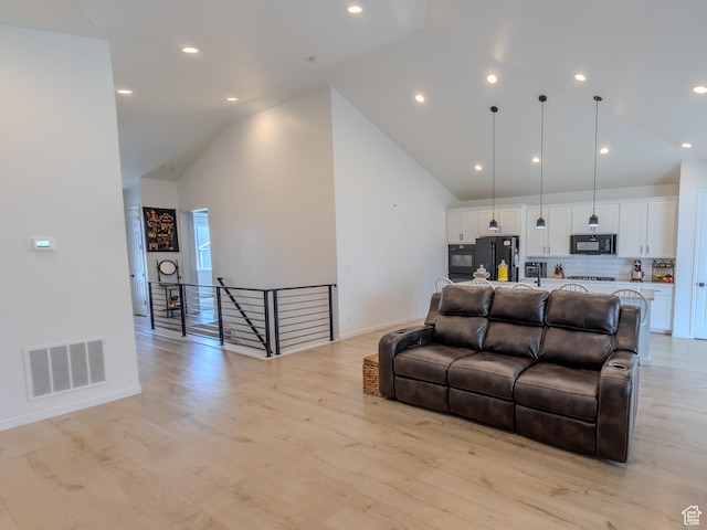 1622 N Baen Way E, Tooele, UT 84074 - living area with high vaulted ceiling, baseboards, light wood finished floors, and recessed lighting