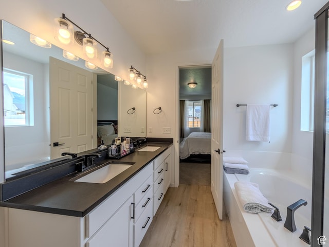 1622 N Baen Way E, Tooele, UT 84074 - bathroom featuring ensuite bathroom, wood finished floors, double vanity, and a garden tub