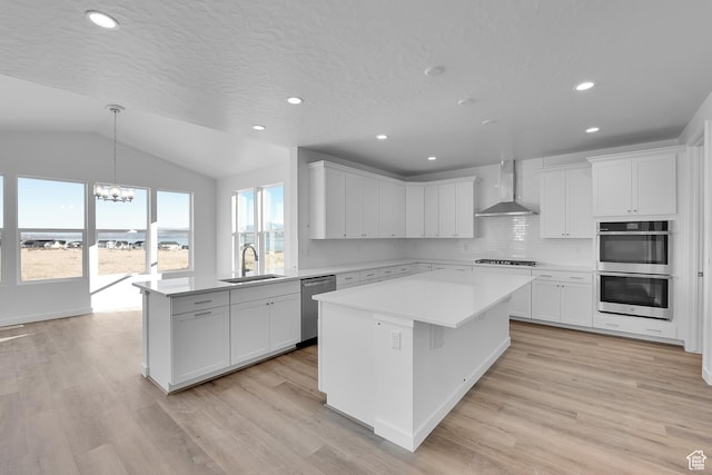 139 E Heron Ave S Unit 809, Saratoga Springs, UT 84045 - kitchen with wall chimney range hood, appliances with stainless steel finishes, a sink, a chandelier, and a peninsula