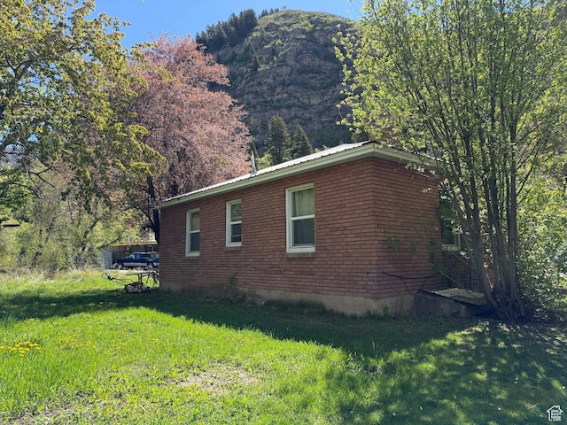 view of side of home featuring a yard and a mountain view
