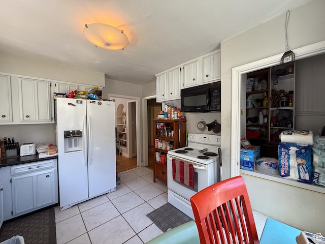 kitchen featuring white appliances, white cabinets, and light tile patterned flooring