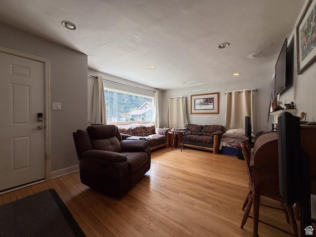 living area with light wood finished floors and recessed lighting