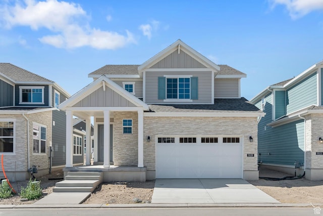 craftsman-style home with stone siding, board and batten siding, concrete driveway, a porch, and a garage