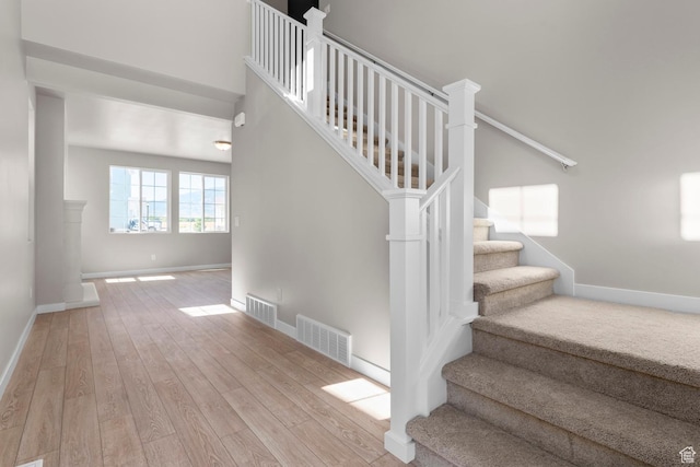 staircase featuring wood finished floors and baseboards