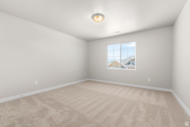 carpeted spare room with baseboards