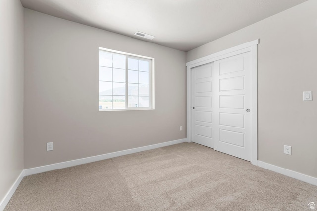 unfurnished bedroom with carpet flooring, baseboards, and a closet