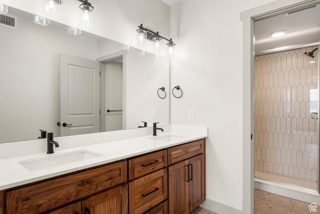 bathroom featuring a stall shower, double vanity, baseboards, and tile patterned floors