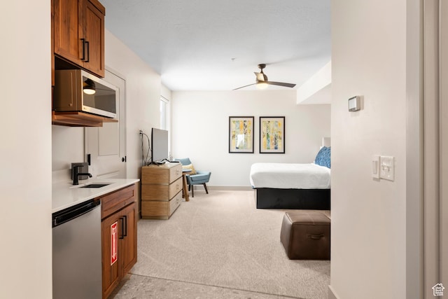 bedroom featuring light colored carpet, a sink, baseboards, and a ceiling fan