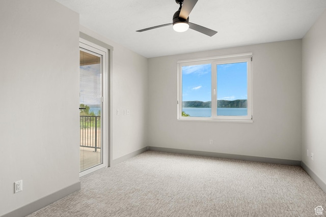 carpeted empty room with baseboards and ceiling fan