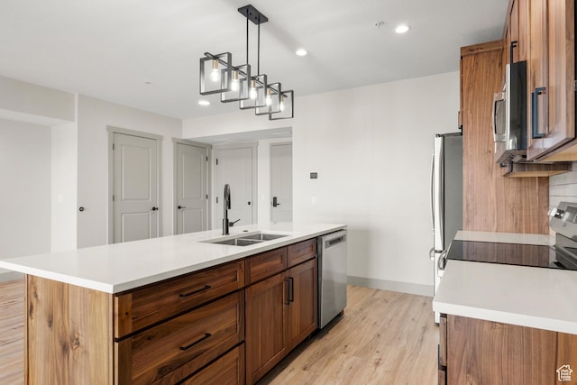 kitchen featuring a sink, stainless steel appliances, brown cabinets, light wood-style flooring, and recessed lighting