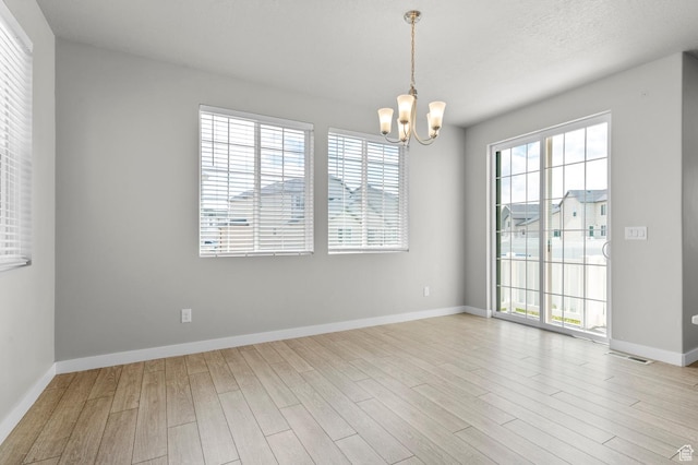 2293 W Prevedel Dr, West Haven, UT 84401 - empty room with wood finished floors, a chandelier, and baseboards