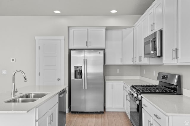 2293 W Prevedel Dr, West Haven, UT 84401 - kitchen with appliances with stainless steel finishes, a sink, light wood finished floors, white cabinets, and recessed lighting