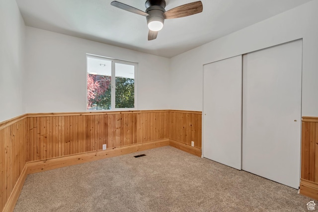 3236 W New World Dr S, West Jordan, UT 84084 - unfurnished bedroom featuring wood walls, a wainscoted wall, carpet, a closet, and ceiling fan