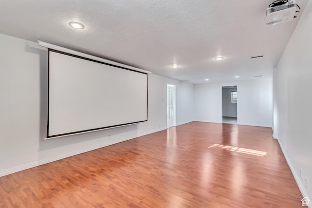 3236 W New World Dr S, West Jordan, UT 84084 - home theater room featuring light wood-style flooring, recessed lighting, baseboards, and a textured ceiling