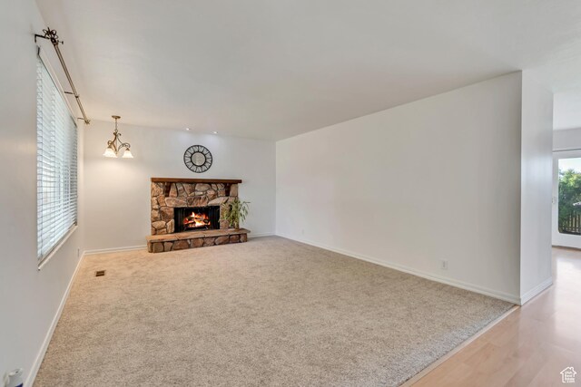 3236 W New World Dr S, West Jordan, UT 84084 - unfurnished living room with baseboards, a fireplace, wood finished floors, and carpet floors