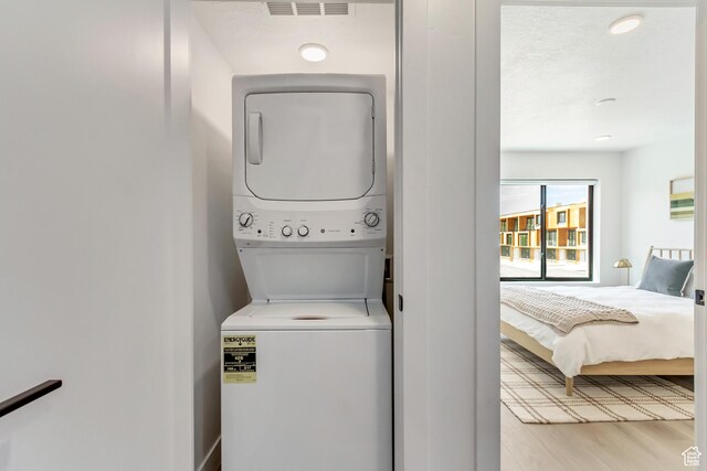 4186 S Main St Unit N220, Millcreek, UT 84107 - laundry area featuring stacked washer / drying machine and light wood-type flooring