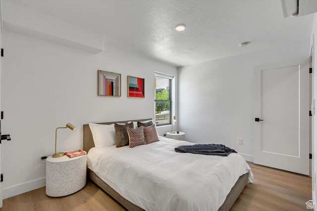 4186 S Main St Unit N220, Millcreek, UT 84107 - bedroom with light wood finished floors, baseboards, and a textured ceiling